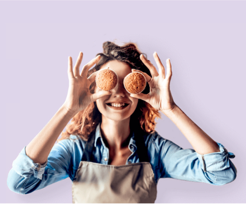photo of a woman holding muffins up to her eyes